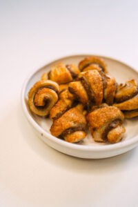 A plate full of baked pastry scrolls (soma)