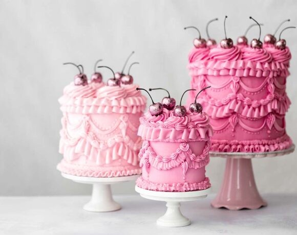 Three beautifully piped pink cakes topped with cherries (piping)