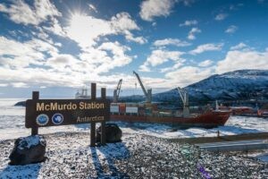 Mcmurdo Station Antarctica sign with cargo ship unloading