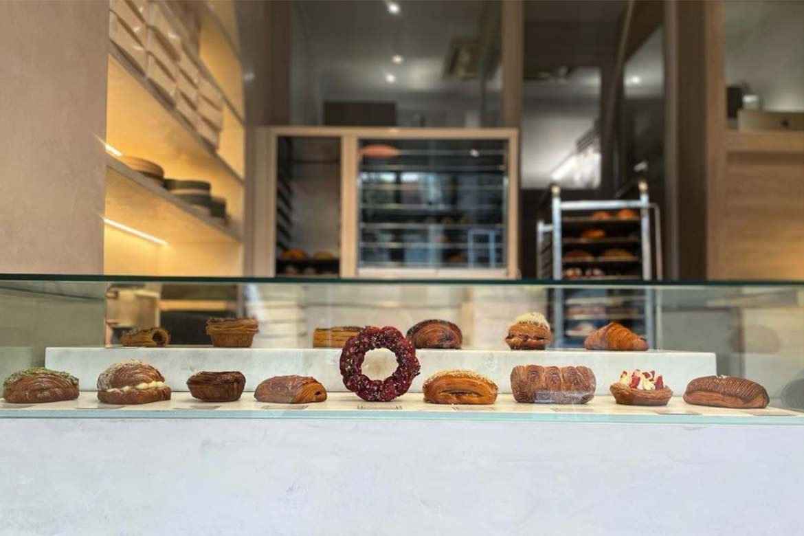 interior of LoDe Pies and Pastries, glass case with pastries inside, and in the background a range of commercial bakery equipment