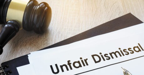 gavel sitting on a table next to a piece of paper with 'unfair dismissal' written along the top