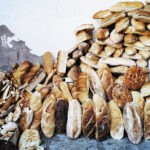Pile of old loaves of bread against an outside wall (wastage)
