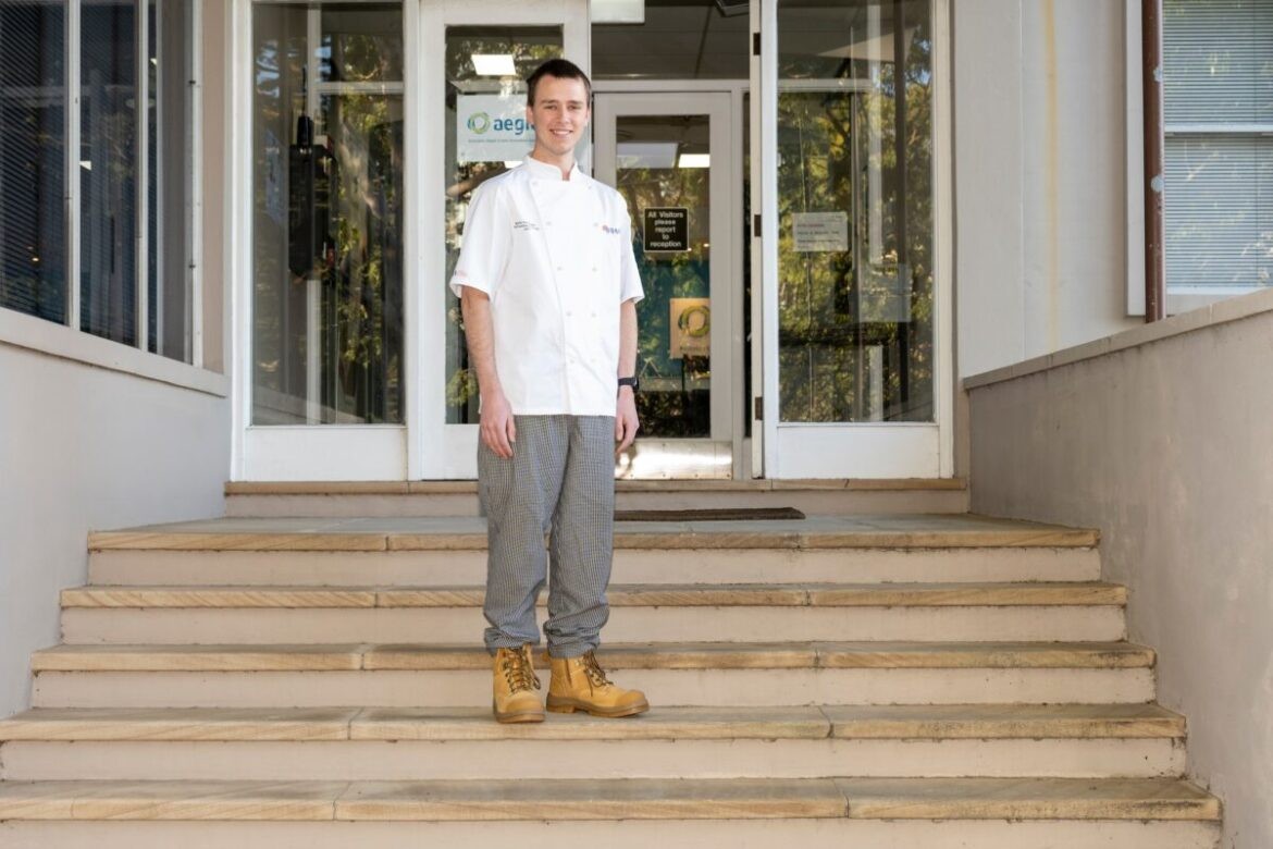 2023 LA Judge Baking Apprentice of the year winner Bjarke Svendsgaard stands on the stairs, smiling.