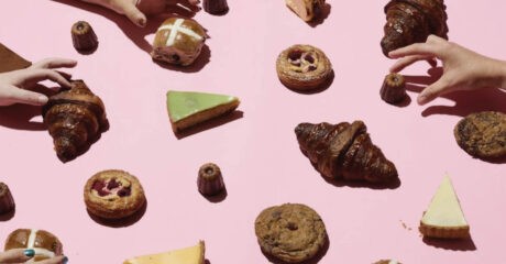 Baker's Dozen features Melbourne's best bakers. Image is numerous baked goods spread across a pink background with hands reaching in to grab them